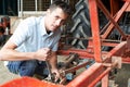 Farmer Working On Agricultural Equipment In Barn Royalty Free Stock Photo