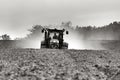 A farmer working on the field with a John Deere tractor.