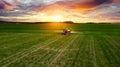 Farmer working in the field on a tractor until sunset Royalty Free Stock Photo