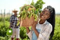 farmer working with organic produce on a farm. Portrait of a farmer holding a basket of produce. Young farmer holding a