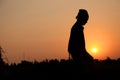 Farmer working in a rice field in sunset.