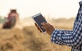 Farmer working on tablet in field during hrvest