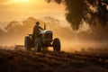 Farmer working on tractor preparing land for sowing crops at sunset, Farmer operating a tractor working in the field in the