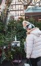 Farmer's market scene with two women senior looking at the prices of fir trees