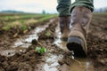 farmers boots trudging through a muddy field Royalty Free Stock Photo