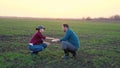 Farmers businessmen with tablet in the field discuss planting crops of plants, production and cultivation of bread