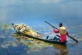 Farmers carrying lilies boating through rural marshland in early morning Royalty Free Stock Photo