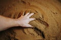 A farmers hands work the ground, with selective focus on the palm,