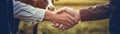 Farmers Handshake Against Backdrop Of Unfocused Agriculture With Cows, Closeup Panoramic Banner