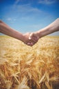 Farmers handshake with wheat field in harvest time