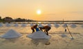 Farmers making heaps of raw sea salt piles with sea. Farm field outdoor. Nature material in traditional salt industry in Thailand