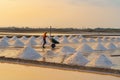 Farmers making heaps of raw sea salt piles with sea. Farm field outdoor. Nature material in traditional salt industry in Thailand