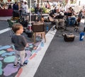 Farmers Market on a bright sunny day showing adults, children, dogs and vendors.