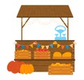 Farmers market stall with wooden crates full of fresh pumpkins. Colorful bunting and weight scale on the stand. Autumn Royalty Free Stock Photo