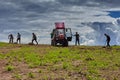 Farmers remove old grass from field uses pitchfork.