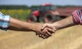 Farmers shaking hands in field during harvest Royalty Free Stock Photo