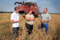 Farmers stand near a harvester in a wheat field Royalty Free Stock Photo