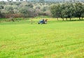 Farmers with a tractor working in a cereal field, rural landscape of Extremadura near Merida, Spain
