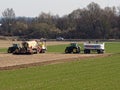 Farmers with tractors on field sowing for food supply