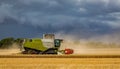 A Combine harvesting under a threatening sky