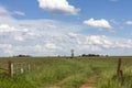 Farmgate and a windpump with clouds Royalty Free Stock Photo