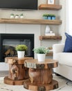 Farmhouse boho fusion cozy living with tree stump tables, white sofa rustic fireplace Royalty Free Stock Photo