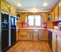 Farmhouse kitchen room with wood cabinets and pink backsplash Royalty Free Stock Photo