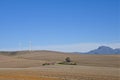Farmhouse in the middle of farmlands with wind turbines in autumn, in South Africa