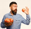 Farming and autumn crops concept. Guy presents homegrown harvest. Farmer with surprised face holds red apple. Man with