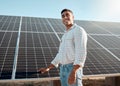Farming is a calling. a young man standing next to a solar panel on a farm.