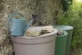 Farming, gardening and agriculture concept - watering cans at farm water tank Royalty Free Stock Photo