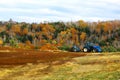 Tractor in field with fall foliage