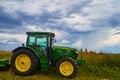 Farming tractor equipment John Deer with stormy clouds