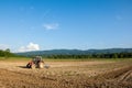 Farming with tractor and plow in field with mountain Papuk in th