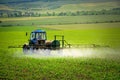 Farming tractor plowing and spraying on field Royalty Free Stock Photo