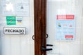 Faro, Portugal - March 16, 2020: Closed front door of the restaurant with coronavirus safety instructions leaflet in Portuguese Royalty Free Stock Photo