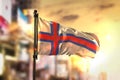 Faroe Islands Flag Against City Blurred Background At Sunrise Ba