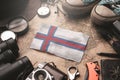 Faroe Islands Flag Between Traveler`s Accessories on Old Vintage Map. Tourist Destination Concept Royalty Free Stock Photo