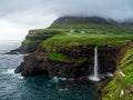 Faroe Islands. MÃÂºlafossur Waterfall and Gasadalur village over the the waterfall. Long exposure. Royalty Free Stock Photo