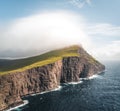 Faroe Islands Traelanipa the slaves rock cliff is seen rising over the ocean next to lake Sorvagsvatn. Clouds and blue Royalty Free Stock Photo