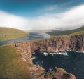 Faroe Islands Traelanipa the slaves rock cliff is seen rising over the ocean next to lake Sorvagsvatn. Clouds and blue Royalty Free Stock Photo