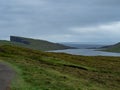 Faroe Islands. TrÃÂ¦lanÃÂ­pan or Slave cliffs on Vagar Island. Green grass fields and sheeps in the foreground.