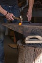 farrier making a traditional horseshoe on a forge