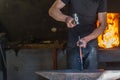 farrier making a traditional horseshoe on a forge