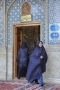 Women in muslim veils entering the mosque and coming out.