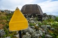 Faded sign warning for microwave radiation at an old radar site..