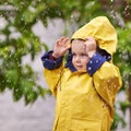 Fascinated by the rain. a young boy playing outside in the rain.