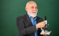 Fascinating biology lesson. happy senior teacher use microscope. chemistry in school laboratory. science experiments Royalty Free Stock Photo