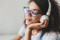 Fascinating young woman with brown skin and long black eyelashes enjoying favorite music in big earphones. Close-up Royalty Free Stock Photo