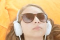 Fascinating young woman enjoying favorite music in big white earphones. Close-up indoor photo of relaxed girl listening song Royalty Free Stock Photo